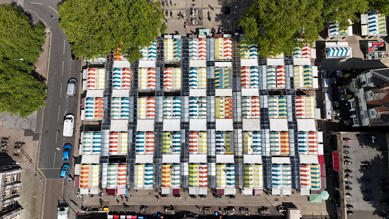 Colorful market stalls from above in Norwich, England, capturing vibrant commerce from a unique perspective.