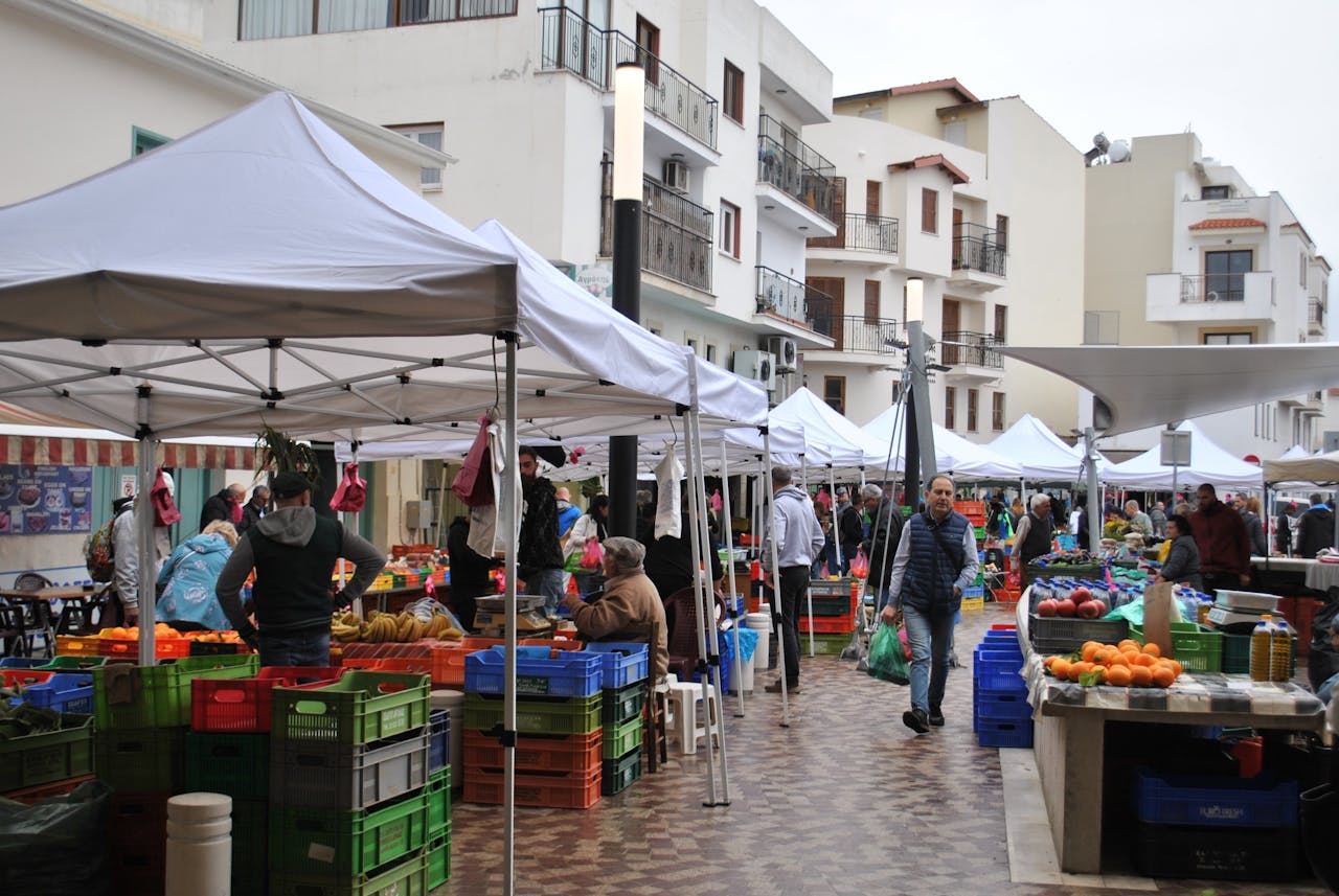Crafting Captivating Headlines: Your awesome post title goes here Busy outdoor market with vendors and shoppers in a city plaza under tents.