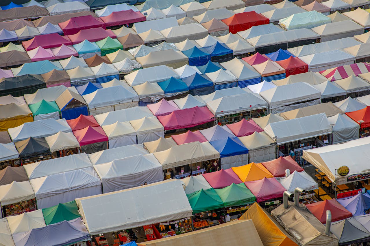 An aerial view showcasing a vibrant market with colorful tents covering stalls.